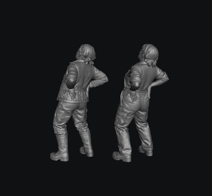 Two grey 3D-rendered scale model figures of a female farmer with a bad back, wearing work clothes and boots.