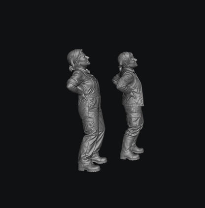 Two unpainted grey resin 3D-printed miniature figures of female farmers standing with hands on their aching backs.
